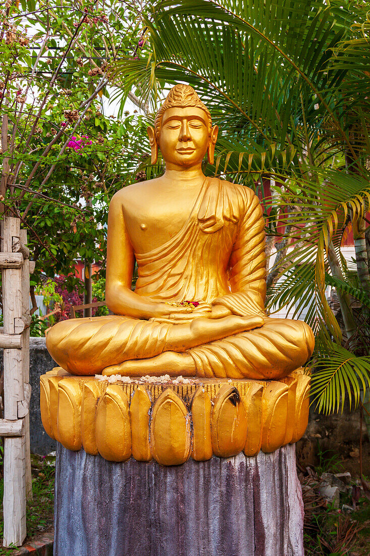 Laos, Luang Prabang. Goldene Buddha-Statue mit verlängerten Ohrläppchen.