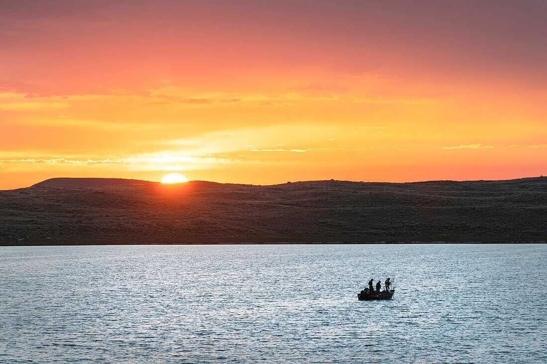 Angeln vom Boot aus auf dem Soda Lake bei Sonnenuntergang, Wyoming