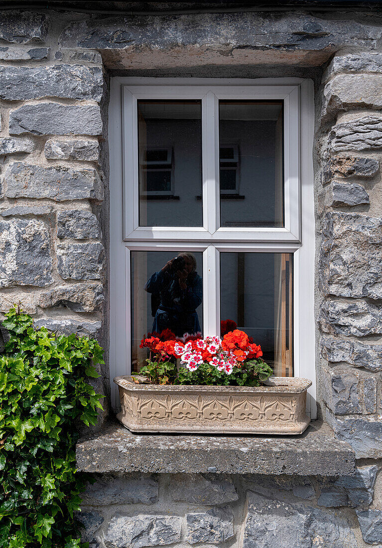Ein Fenster zaubert ein Lächeln auf die Gesichter der Passanten in dem historischen Dorf Cong, Grafschaft Mayo, Irland.