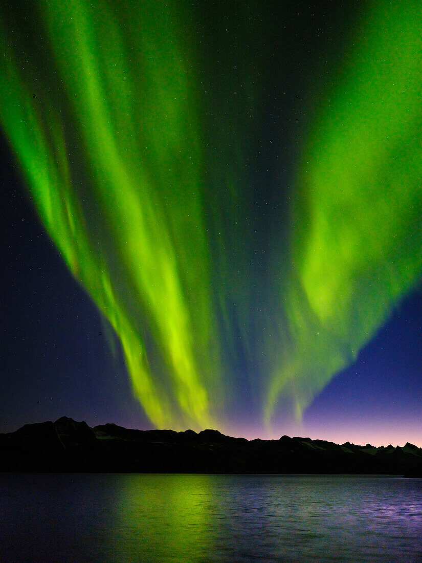 Northern lights over Angmagssalik Fjord near settlement Kuummiit. Ammassalik area in East Greenland, Danish Territory