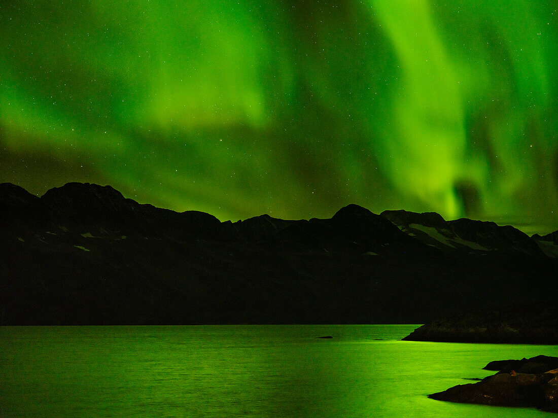 Nordlichter über dem Angmagssalik Fjord nahe der Siedlung Kuummiit. Ammassalik-Gebiet in Ostgrönland, Dänisches Territorium