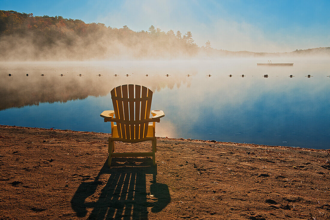 Kanada, Ontario, Silent Lake Provincial Park. Muskoka-Stuhl und Morgennebel am Silent Lake.