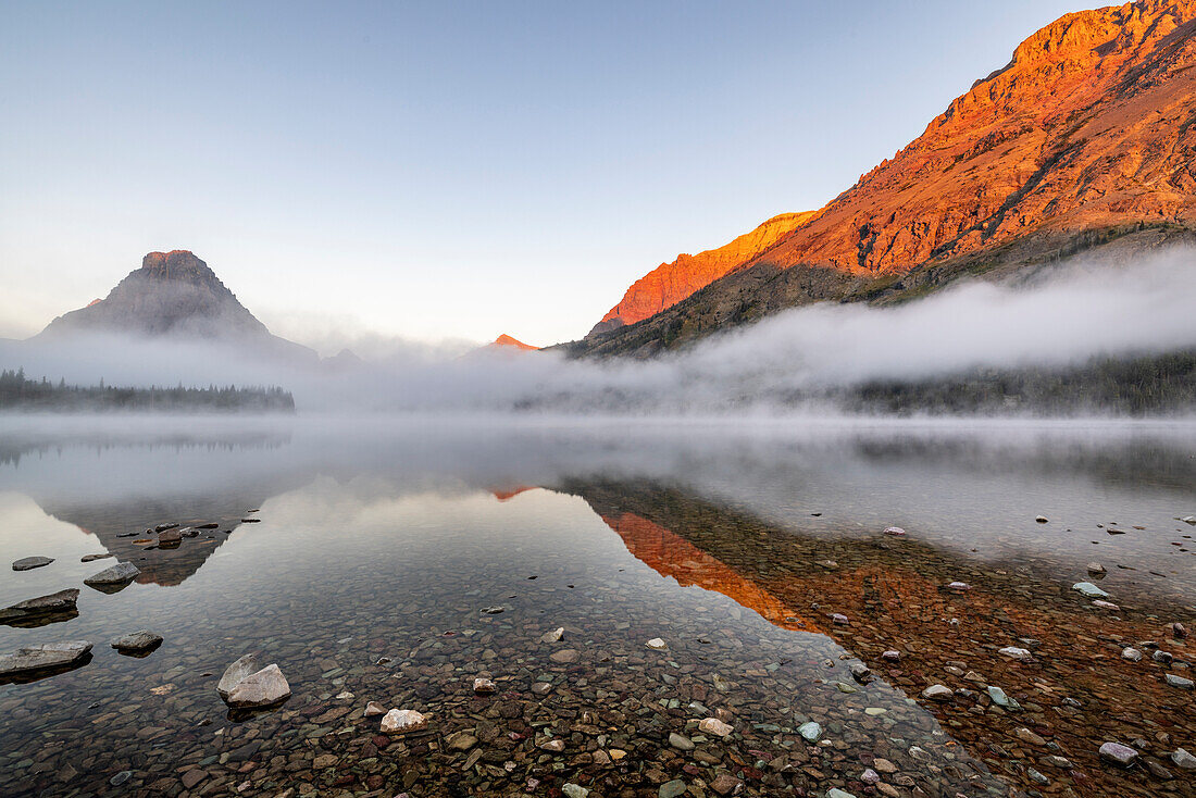 Nebliger Sonnenaufgang über dem Two Medicine Lake im Glacier National Park, Montana, USA