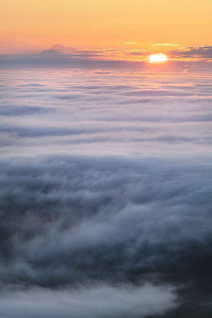 Fog over Puget Sound At sunrise seen from Olympic Mountains. Mount Baker is in the distance