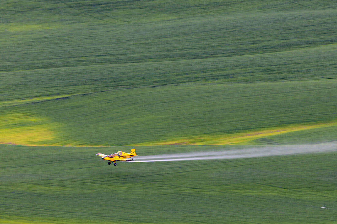 Sprühflugzeug beim Ausbringen von Chemikalien auf Weizenfeldern von Steptoe Butte bei Colfax, Bundesstaat Washington, USA