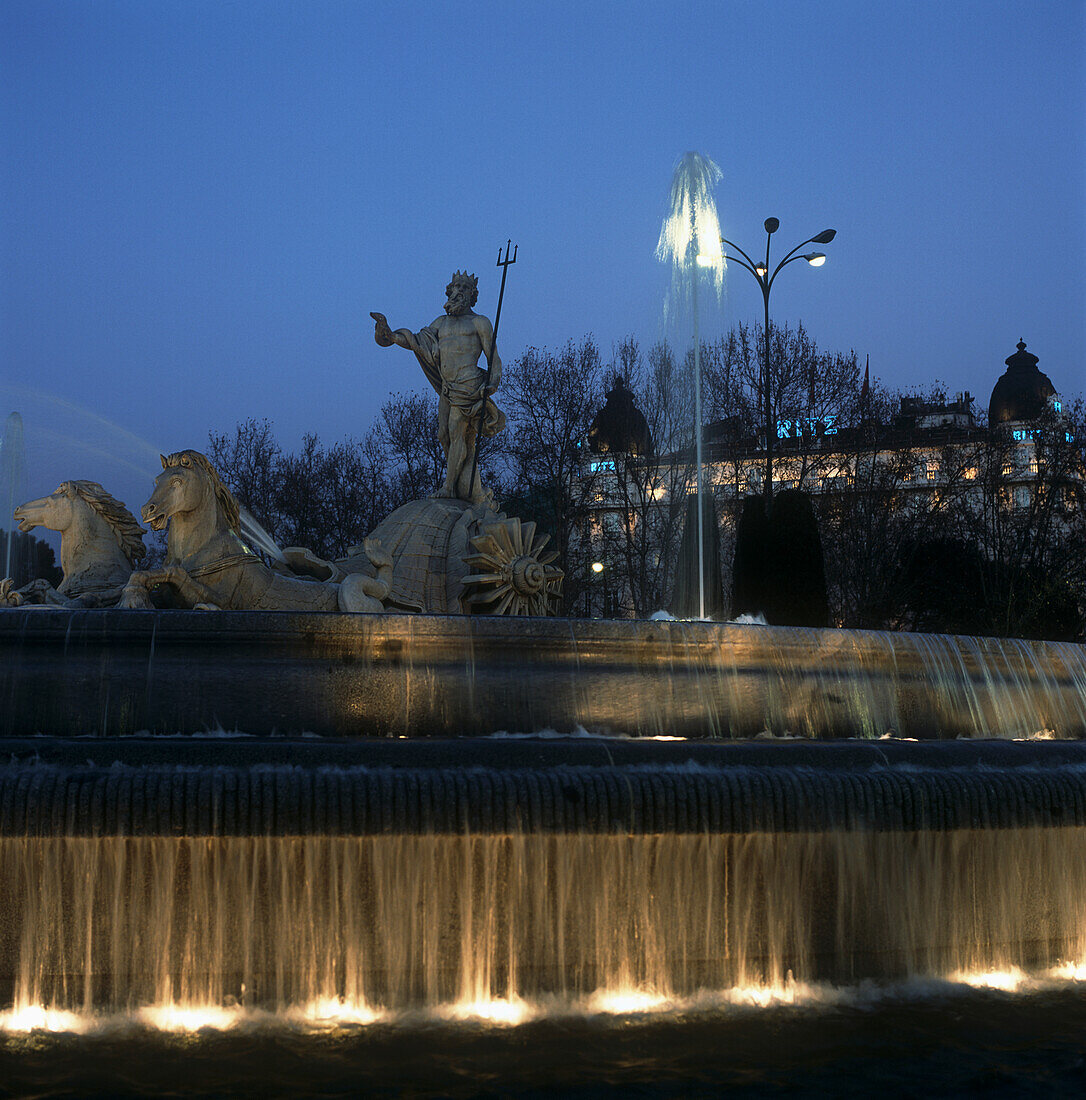 Neptunbrunnen und Ritz Hotel in der Abenddämmerung beleuchtet