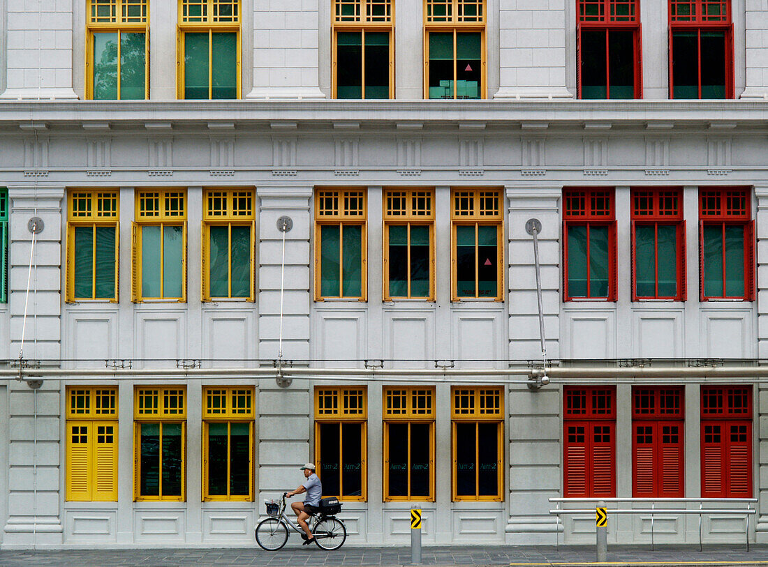 Person fährt mit dem Fahrrad an einem Gebäude in der Hill Street vorbei