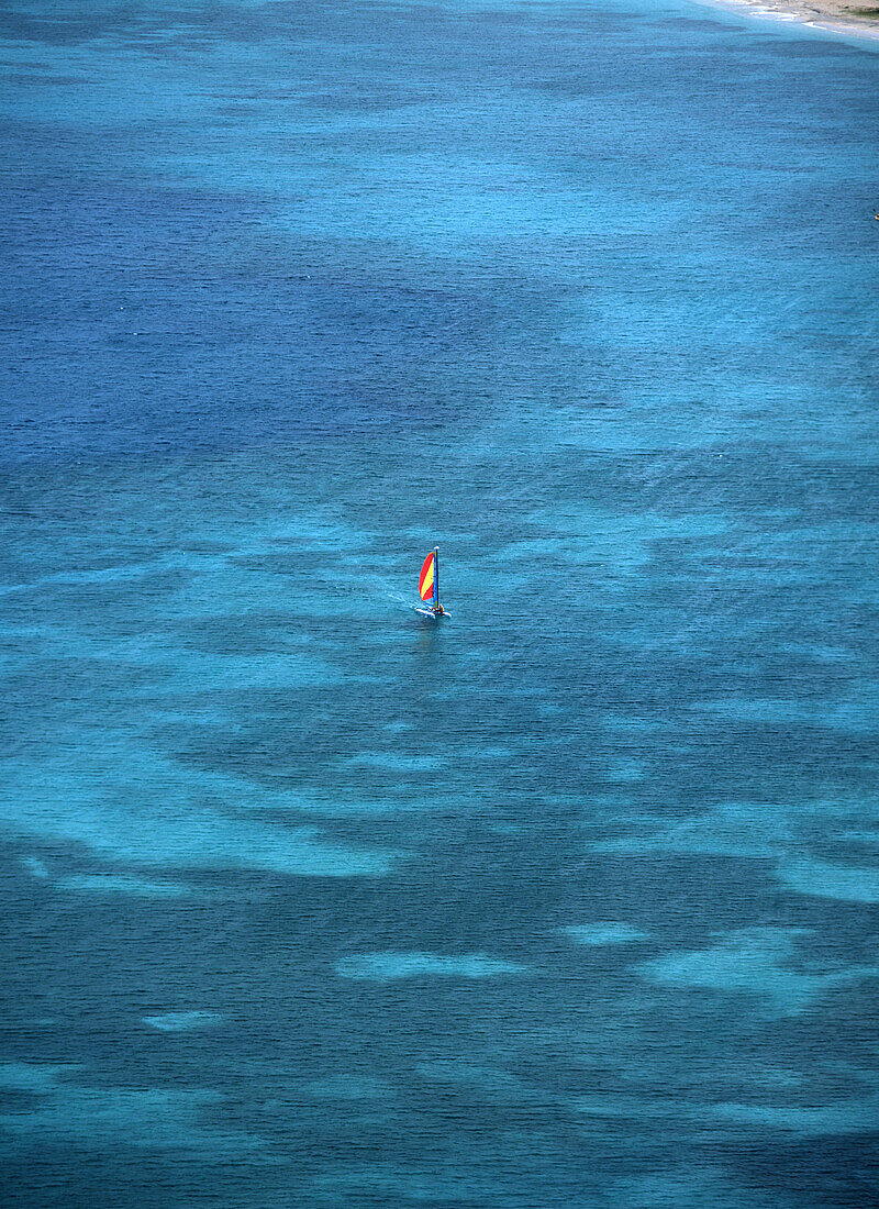 Kleiner Katamaran segelt im seichten Wasser, Reduit Beach, Rodney Bay, von der Spitze des Forts aus gesehen, Pigeon Island, St Lucia.