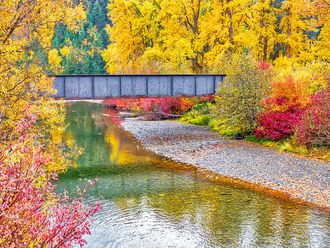 USA, Bundesstaat Washington, Cle Elum, Kittitas County. BNSF-Eisenbahngleise, die den Yakima-Fluss überqueren, umgeben von Herbstfarben.