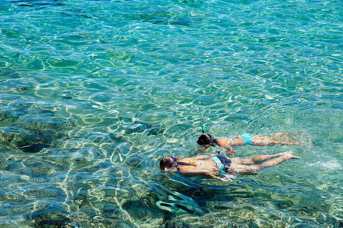 Girls Snorkeling In The Clear Waters Of Cala Sant Pere, Alcudia, Mallorca, Balearic Islands, Spain