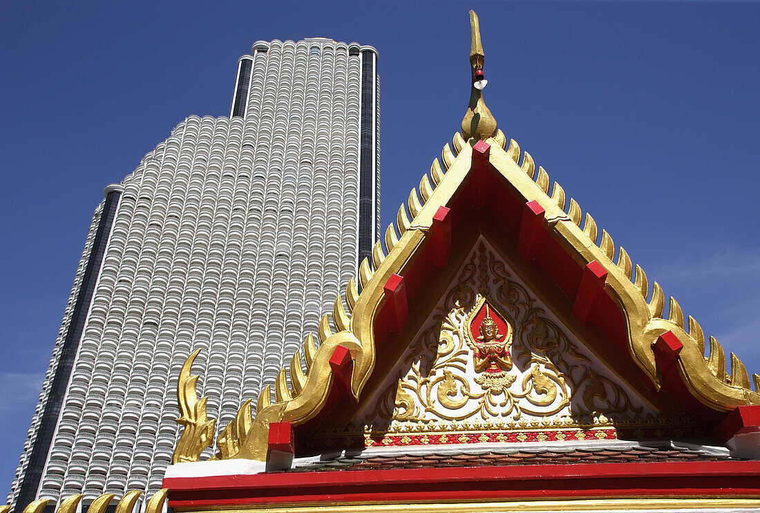 Architecture contrasts of huge high rise building and temple detail from unnamed wat in Bangkok, Thailand.