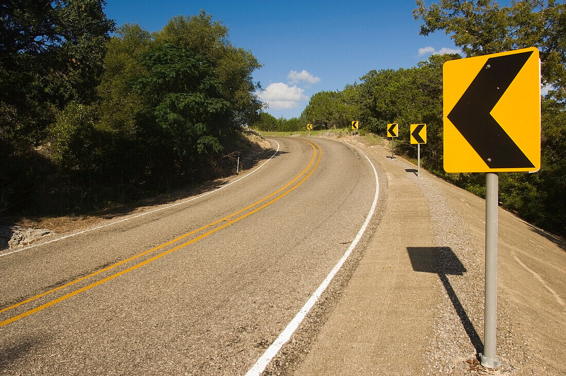 Gelbe Kurvenwarnschilder auf der Ranch Road 187 in Richtung Norden in Bandera County, Texas, USA