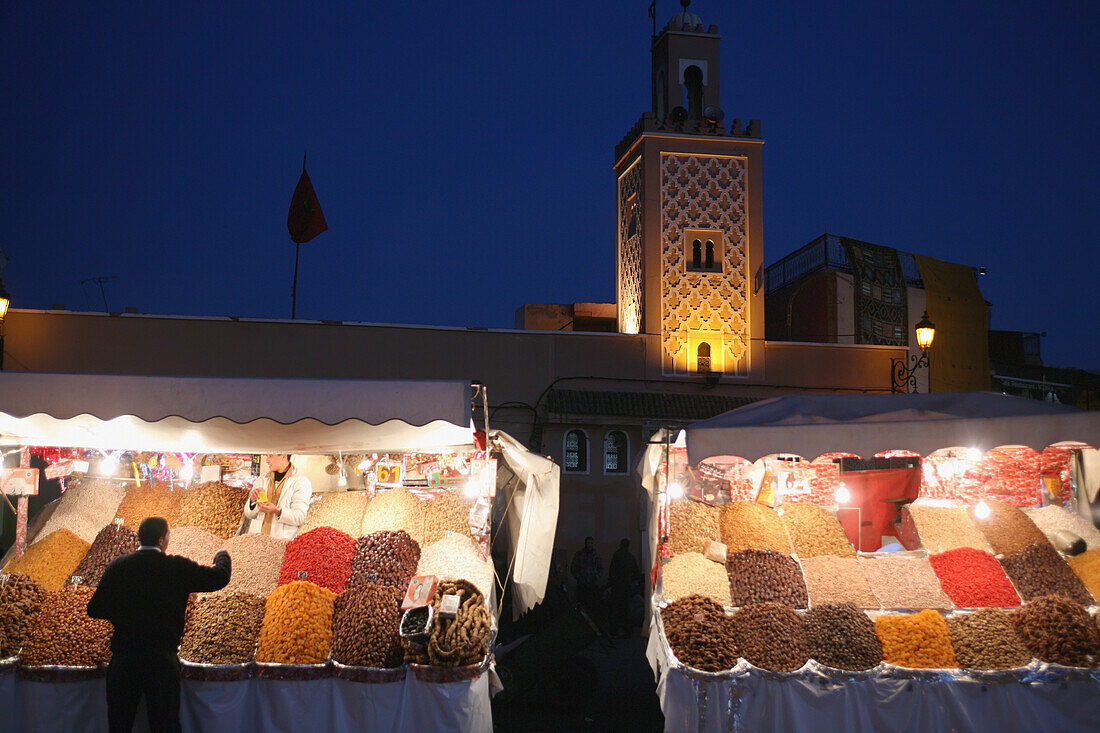 Night Time Shot Of Fruit And Nuts For Sale At A Street Stall On Djamaa El Fna, With Mosque In The Background, The Main Square In Marrakesh, Morocco; Marrakesh, Morocco