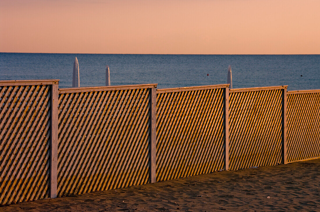 A fence on the beach at the water's edge; Paestum, Campania, Italy