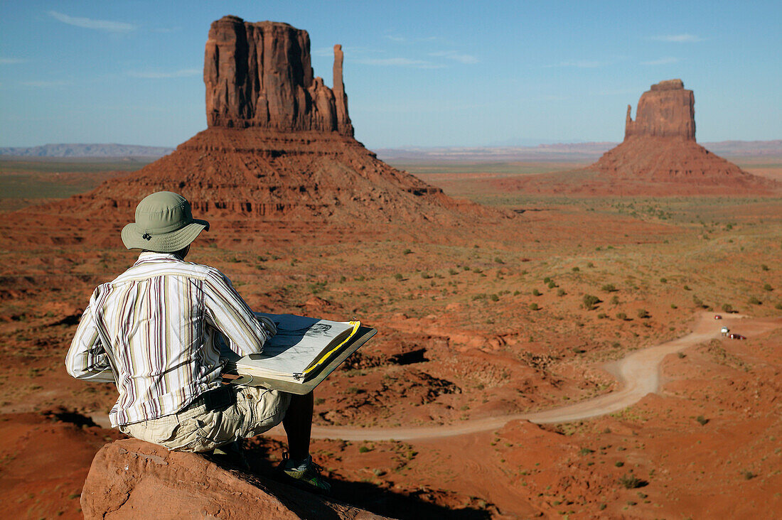 Artist sketching the East and West Mitten Buttes of Monument Valley; Arizona, United States of America