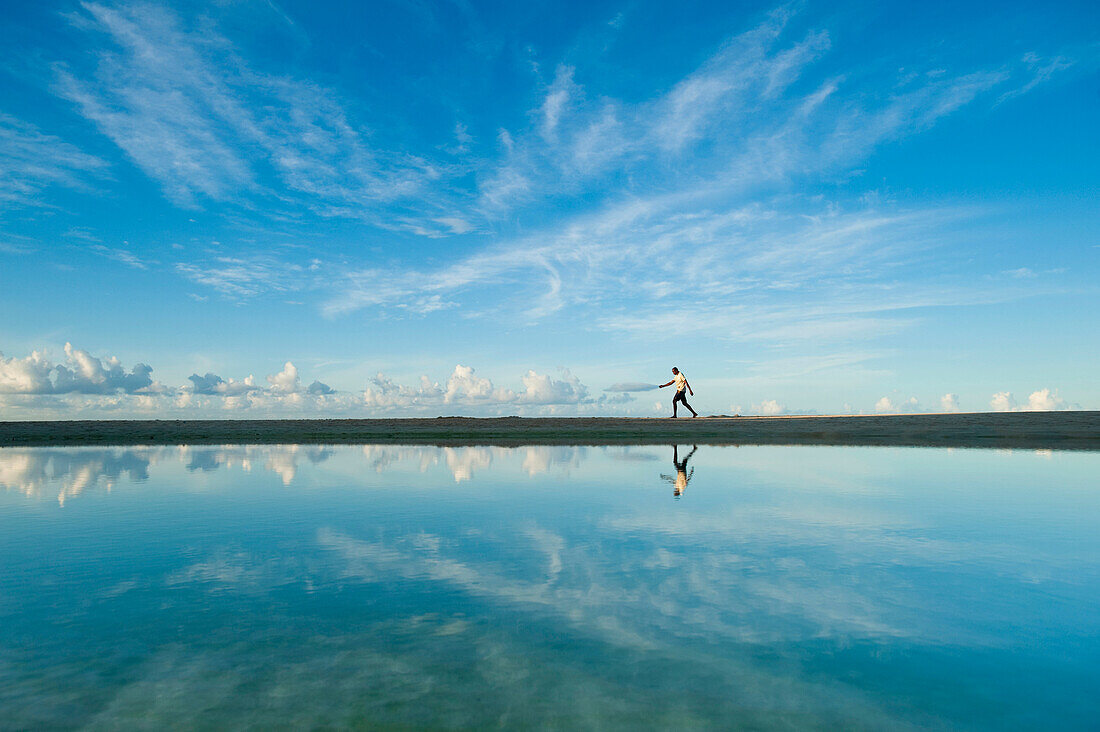 Mann geht an einem flachen Teich vorbei, Brighton Beach, Barbados.