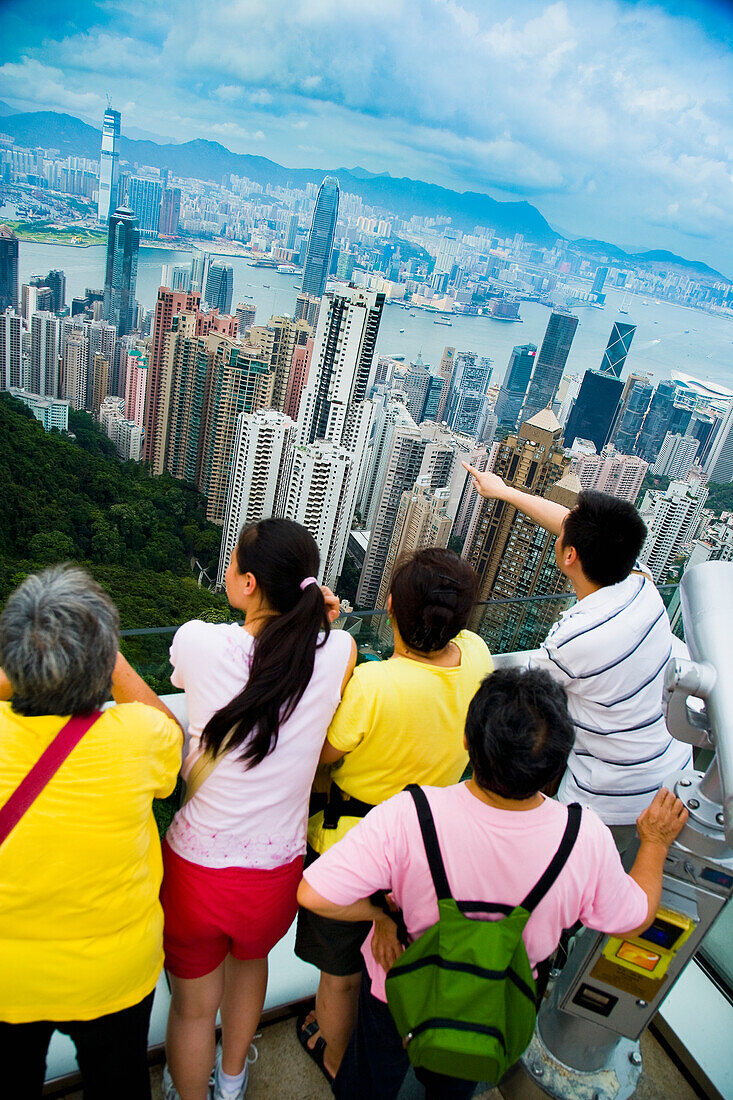 Touristen genießen den Blick vom Victoria Peak über die Skyline der Hochhäuser von Victoria Harbour, Hong Kong Island und Kowloon; Victoria Peak, Hong Kong Island, China, Asien.
