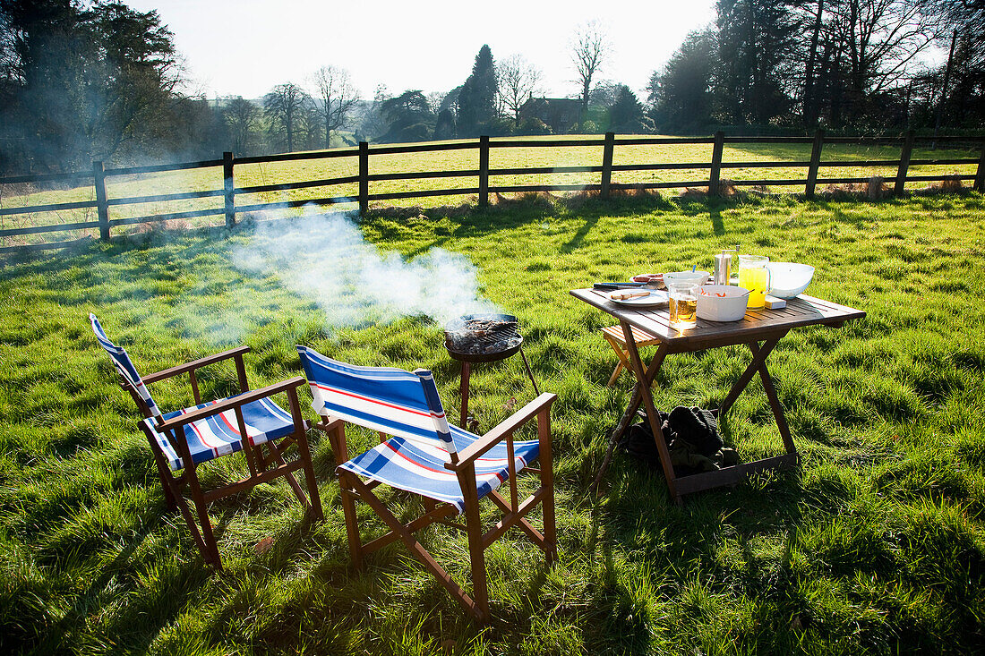 Stühle, Tisch und Grill im Garten eines ländlichen Cottage in Devon, Großbritannien