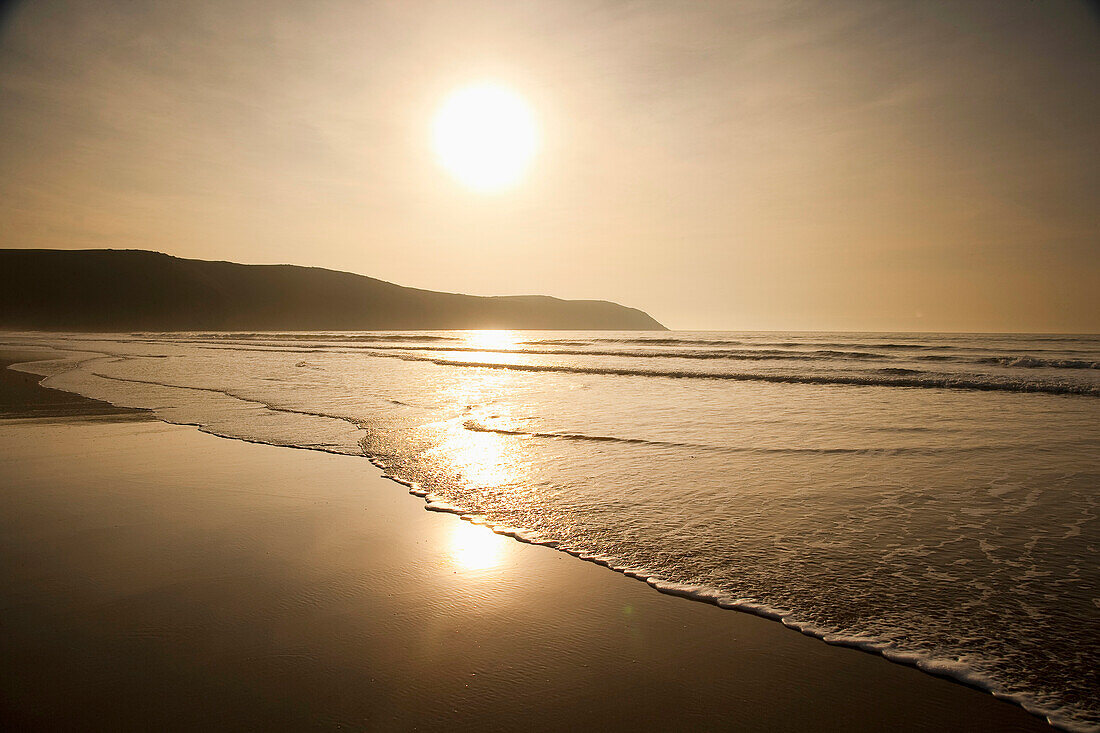 Waves Lapping Up On The Shore At Sunset At Putsborough Sands, North Devon, Uk