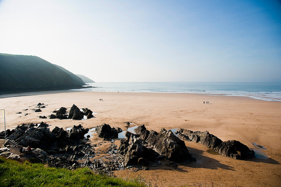 Goldener Sand und Felsen am Strand von Putsborough Sands, Nord-Devon, Großbritannien