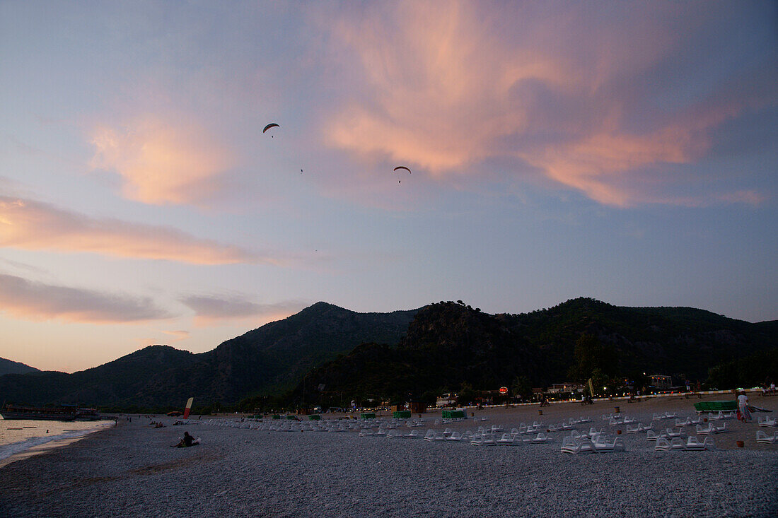 Gleitschirmflieger bei Sonnenuntergang über Oludeniz an der Türkis-Küste, Südtürkei