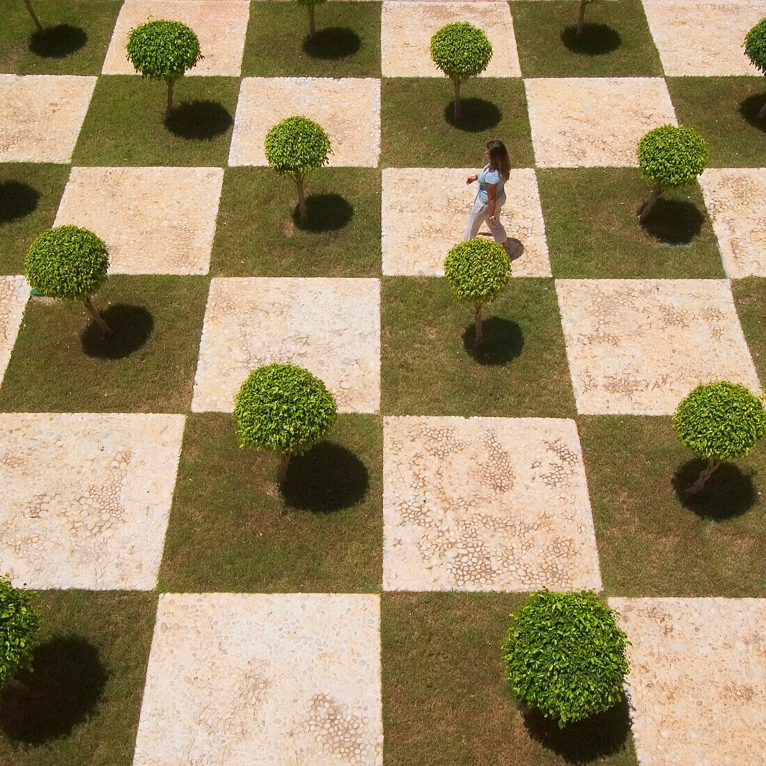 Woman Walking Across Manicured Courtyard, Dominican Republic.