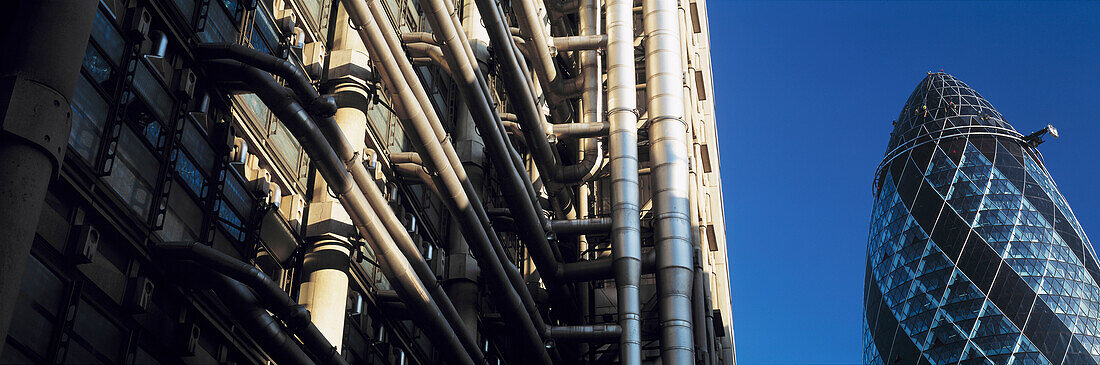 Blick am Lloyds-Gebäude vorbei in Richtung Norman Fosters "Gurke" oder Swiss Re-Gebäude, London, Großbritannien.