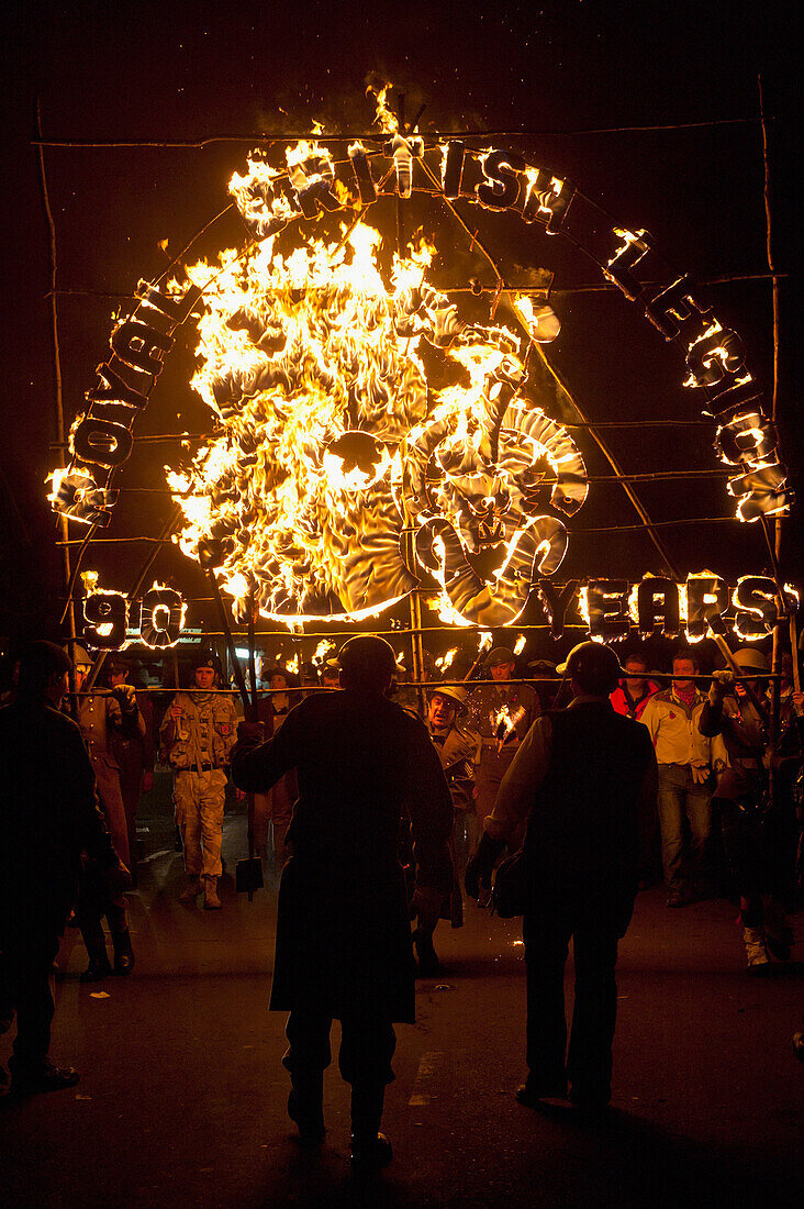 Leute von der East Hoathly & Halland Carnival Society tragen ein großes brennendes Banner durch East Hoathly in der Nacht des Freudenfeuers, East Sussex, Großbritannien