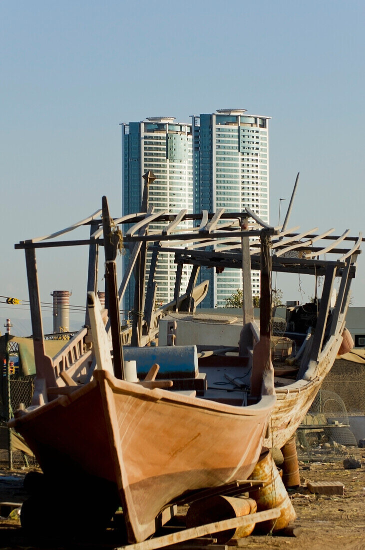 United Arab Emirates, View of old dhow and skyscraper in background; Ras Al Khaimah