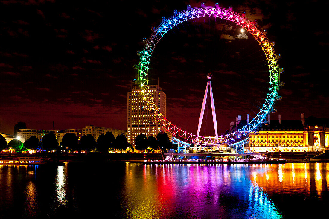Riesenrad alias London Eye beleuchtet mit den Regenbogenfarben während der Pride Night, London, UK