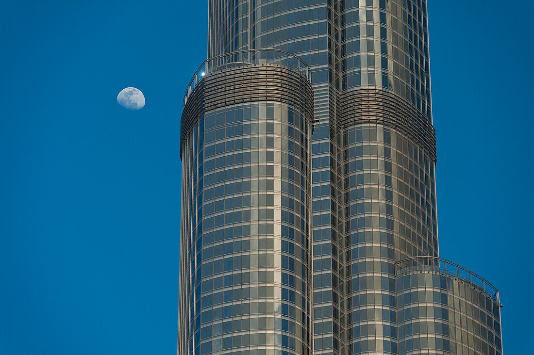 VAE, Detail des Burj Khalifa mit dahinter aufsteigendem Mond; Dubai