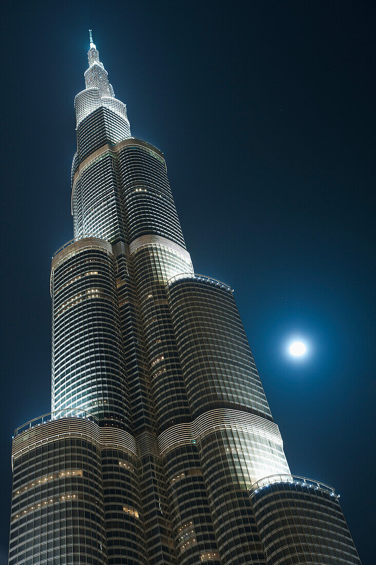 Dubai, Sonnenuntergang und ziehende Wolken hinter dem Burj Khalifa bei Nacht