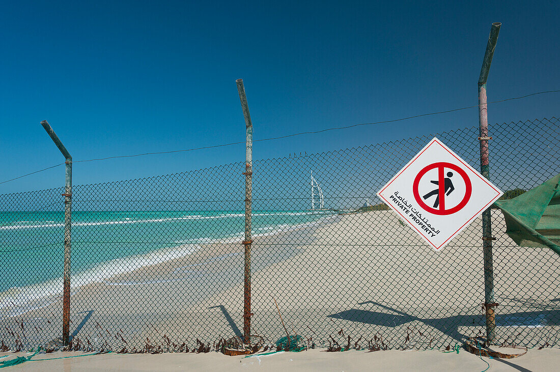 UAE, Fenced off beach with the Burj Al Arab in distance; Dubai