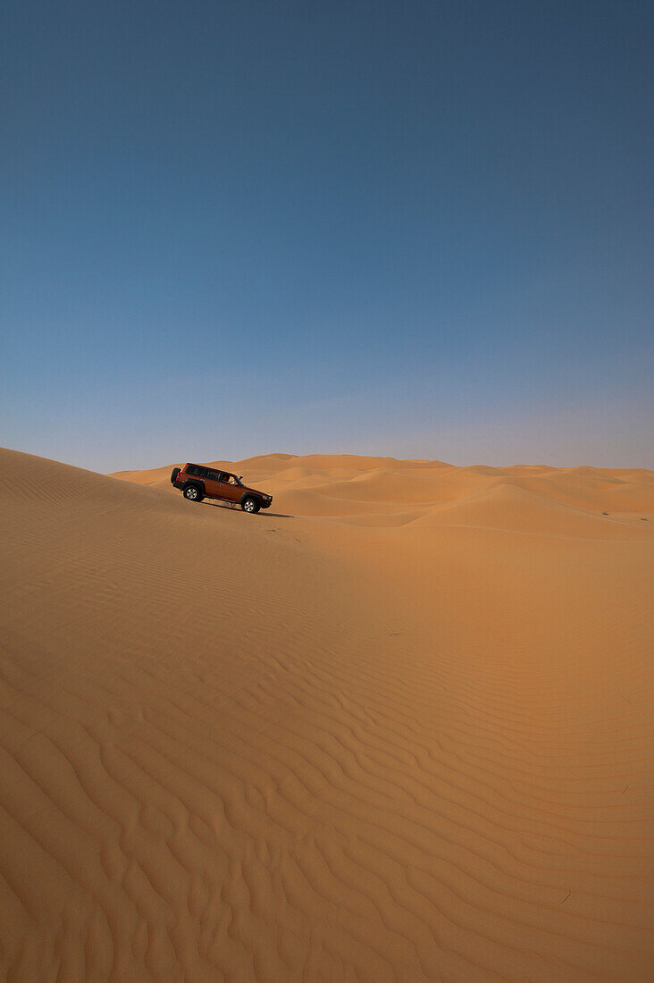 UAE, Abu Dhabi, Four wheel drive going across sand dunes; Liwa