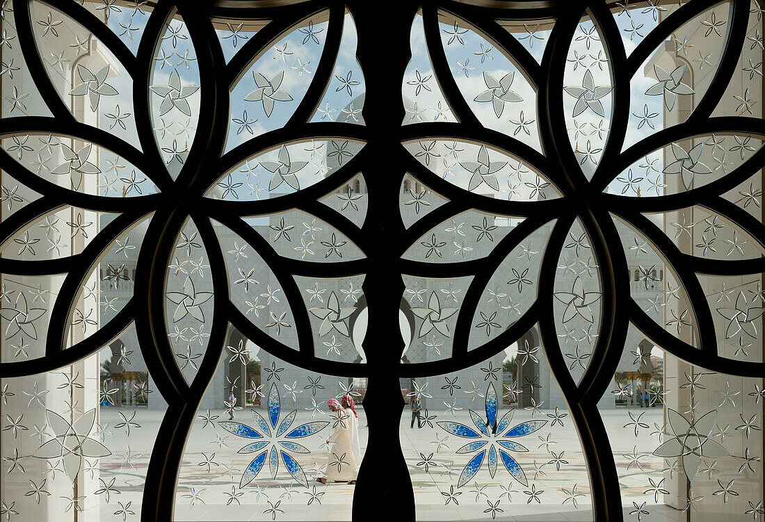 Looking Out Through The Main Doors To People Walking Through Courtyard Of The Sheikh Zayed Grand Mosqueabu Dhabi, United Arab Emirates