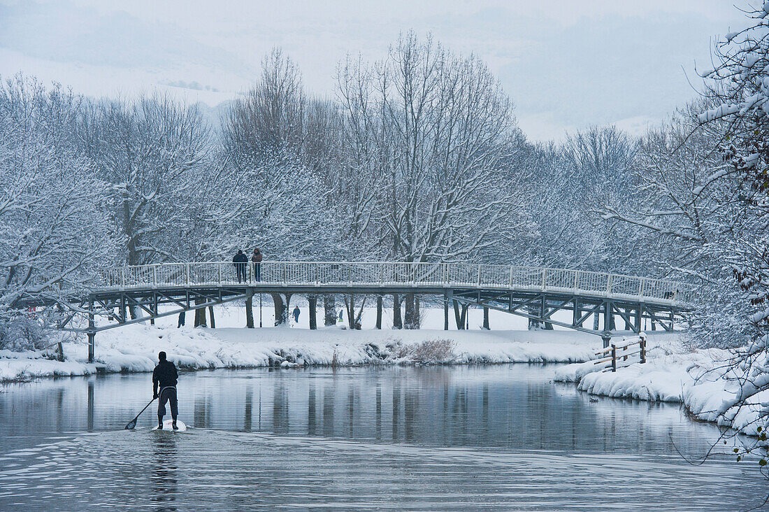 Großbritannien, East Sussex, Mann paddelt bei Schnee auf dem Fluss Ouse; Lewes