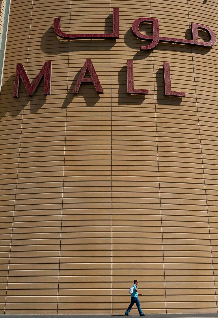 VAE, Mann geht an großem Schild für die Dubai Mall vorbei; Dubai