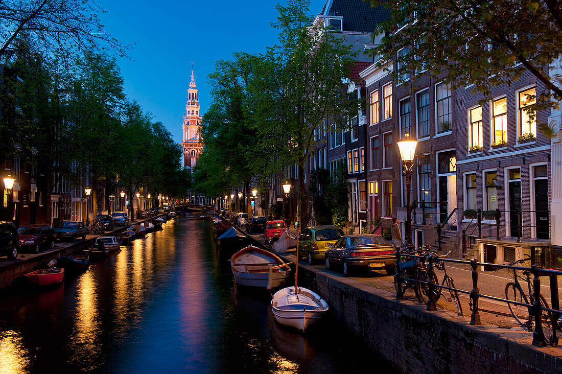 Blick entlang der kleinen Gracht mit der Spitze der Zuiderkerk Kirche am Ende in der Abenddämmerung; Amsterdam, Holland.