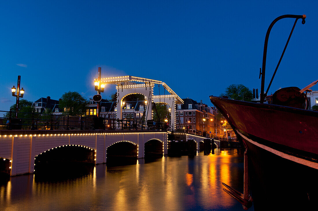Magere Brug oder dünne Brücke in der Abenddämmerung, Amsterdam, Holland.