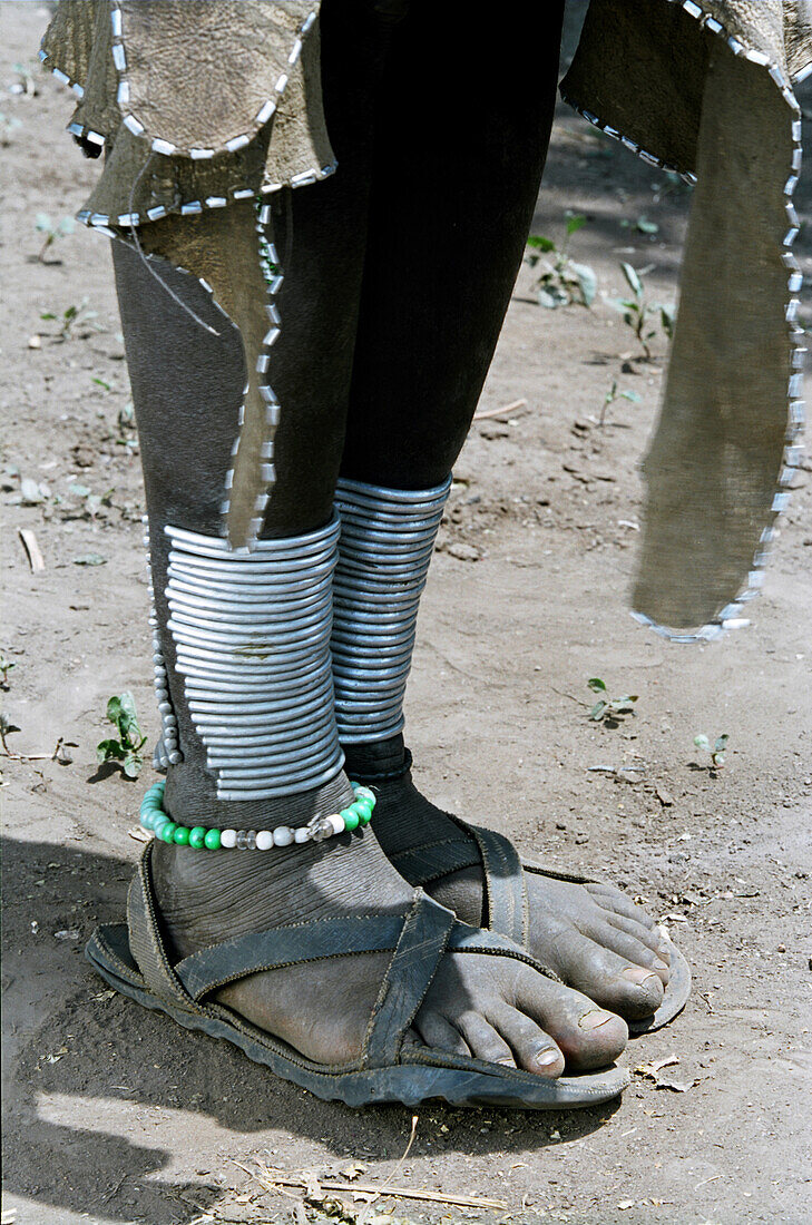 Eine Frau vom Stamm der Mursi zeigt traditionellen Beinschmuck. Makki / Süd-Omo / Südliche Region der Nationen, Nationalitäten und Völker (Äthiopien).