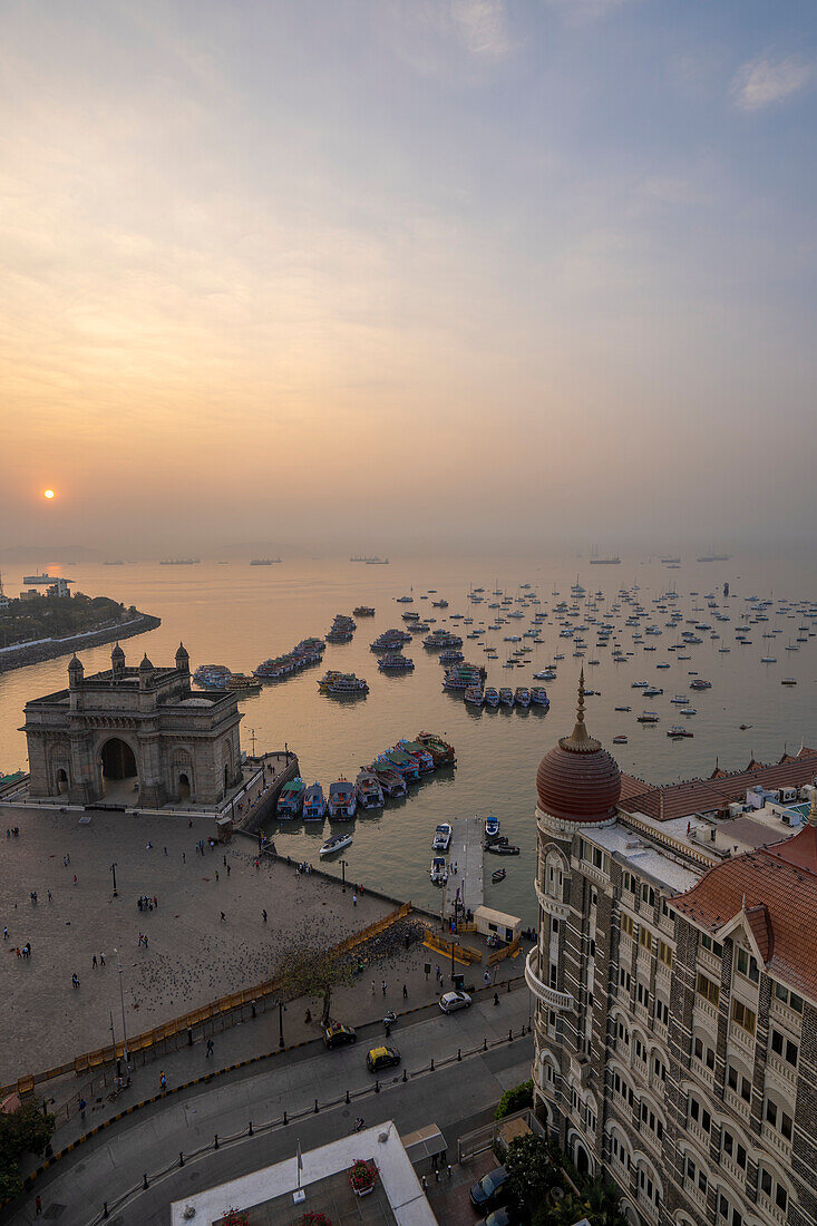 Sonnenaufgang über dem Hafen mit dem Gateway of India und dem Taj Mahal Palace Hotel in der Morgendämmerung; Mumbai, Bombay, Indien