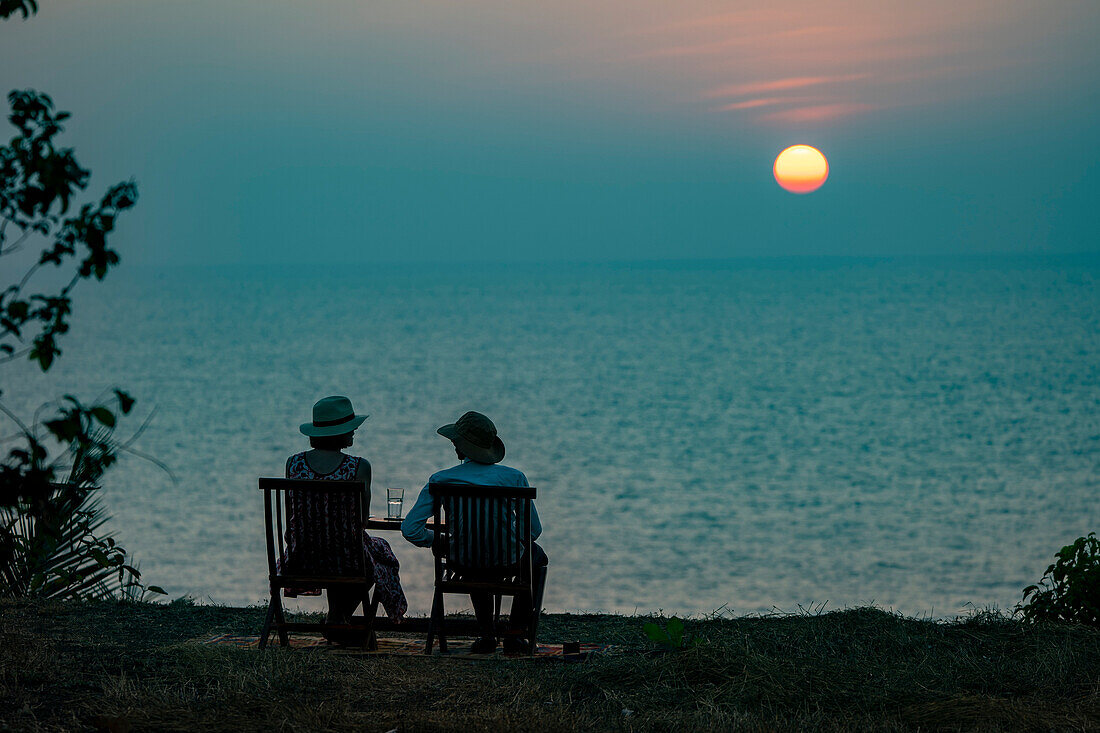 Gäste genießen Sundowner (Cocktails) auf einer Klippe oberhalb des Cabo Serai Boutique Hotels; Cabo, Goa, Indien