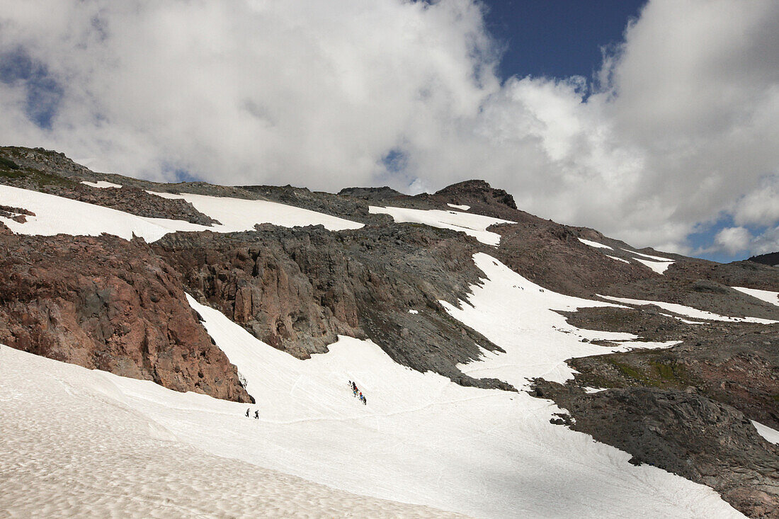 Several hikers make a trail through the snow on Mount Rainier.; Mount Rainier National Park, Washington