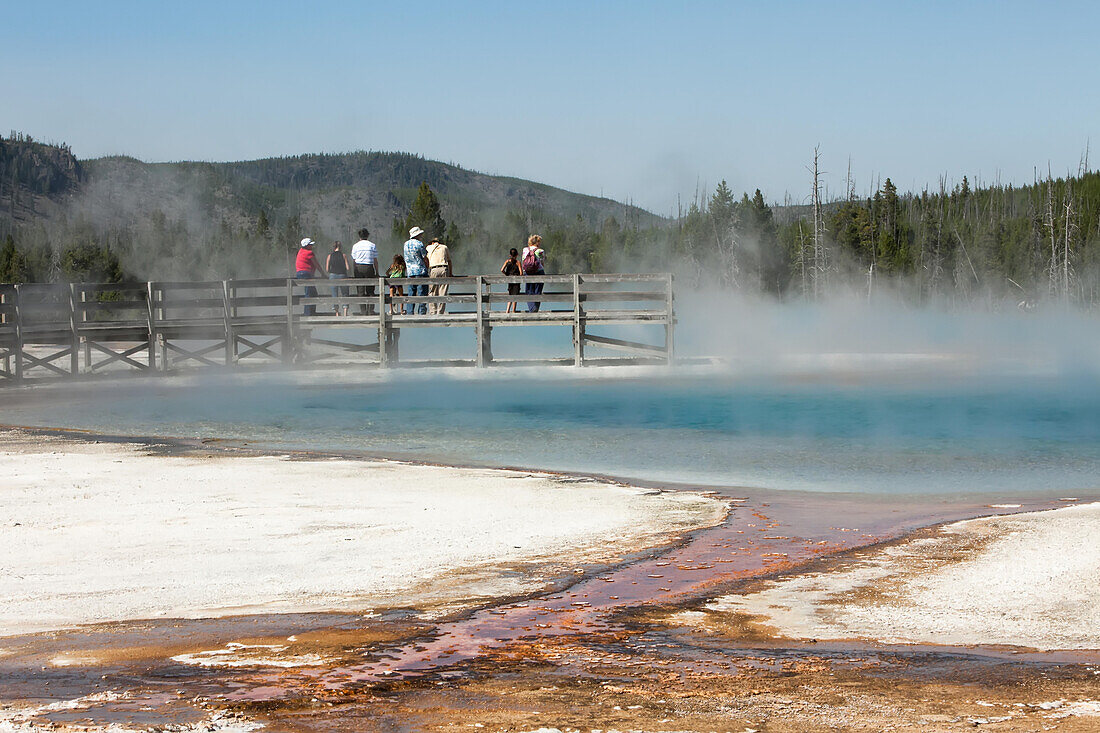 Touristen beobachten und fotografieren auf einer Promenade geothermische Erscheinungen in einem Geysirbecken; Yellowstone National Park, Wyoming