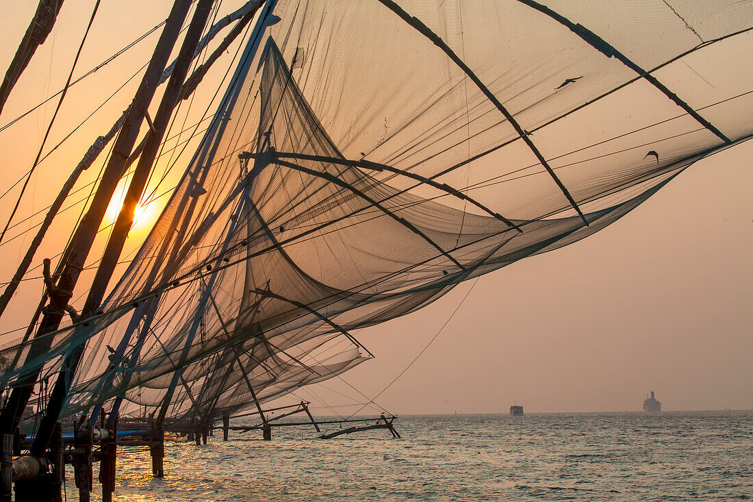 Traditional, ‘Chinese’ fishing nets at sunset in the mouth of the harbor; Kochi, Kerala, India