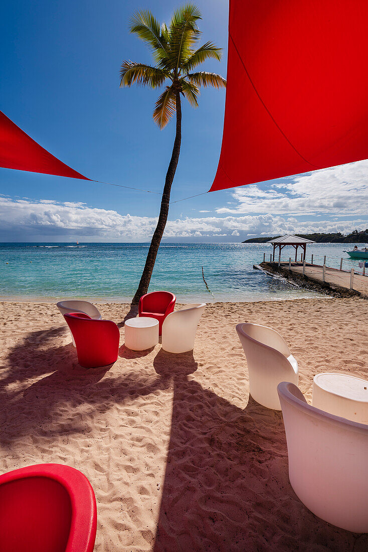 Rote und weiße Strandmöbel am Sandstrand von Plage de la Caravelle, Sainte-Anne auf Grande-Terre; Guadeloupe, Französische Westindische Inseln