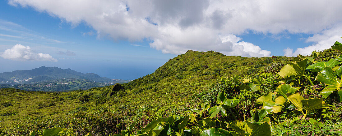 Wolkenformation und Berglandschaft mit der Stadt Basse-Terre von den Hängen des Vulkans La Soufriere aus gesehen, einem aktiven Stratovulkan auf der Insel Basse-Terre; Guadeloupe, Französisch-Westindien