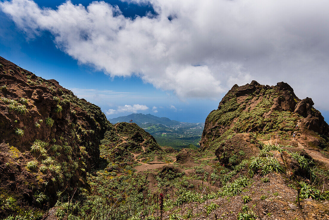 Hikers standing at the top of the rocky cliffs of the volcano, La Soufriere overlooking the countryside on Basse-Terre; Guadeloupe, French West Indies