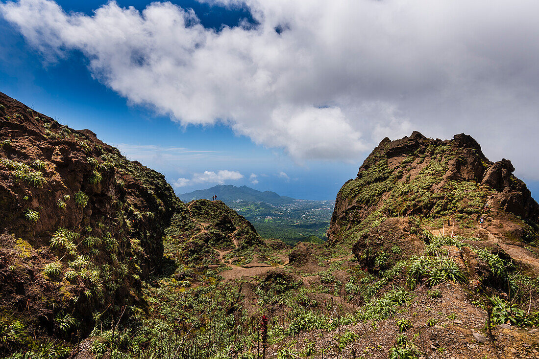 Wanderer stehen oben auf den felsigen Klippen des Vulkans La Soufriere und überblicken die Landschaft auf Basse-Terre; Guadeloupe, Französische Westindische Inseln