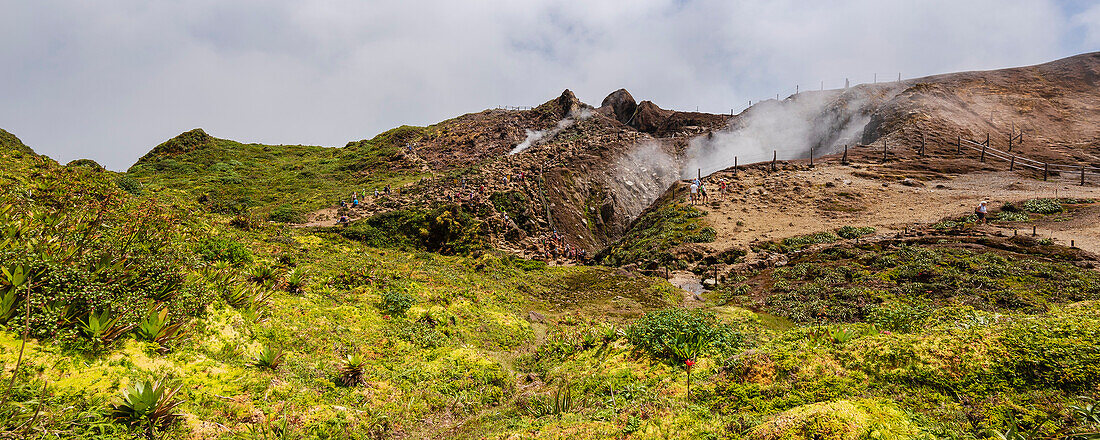 People hiking along the mountain trail near the top of the La Grande Soufriere  with it's crater emitting gases, Basse-Terre; Guadeloupe, French West Indies